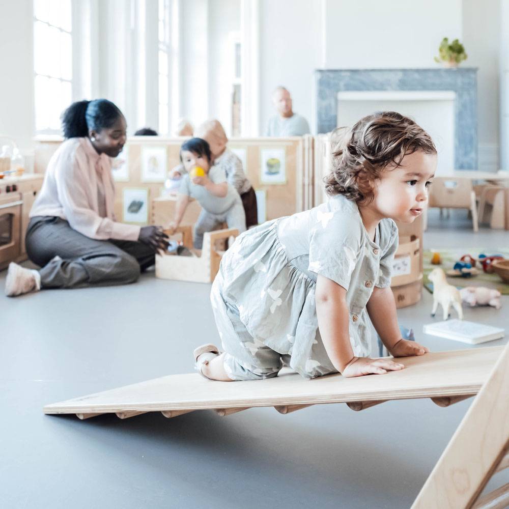 Een dreumes speelt op het klimelement op de dreumesgroep van de kinderopvang van Kindergarden.